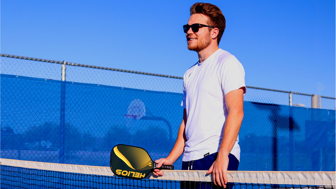 Young man standing at net of Pickleball Court